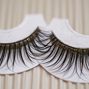 A close-up of a pair of false eyelashes with a classic vintage-style pattern.